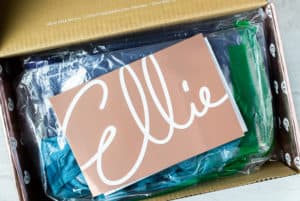 An open box with an Ellie envelope on top and clear bags with athletic wear in them