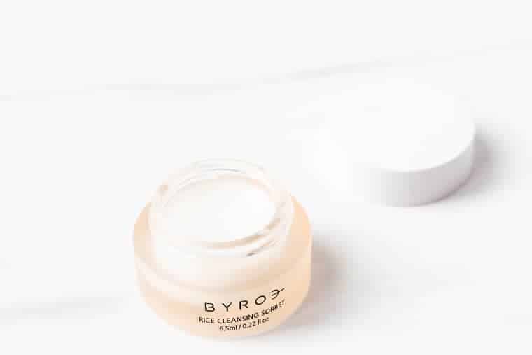 Byros cleansing balm on a white background with the lid off next to it