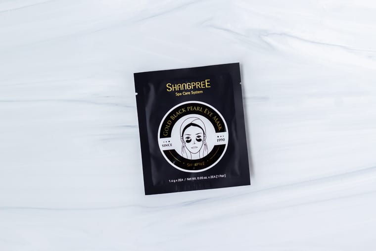 Shangpree Gold Black Pearl Eye Mask in package on a white background