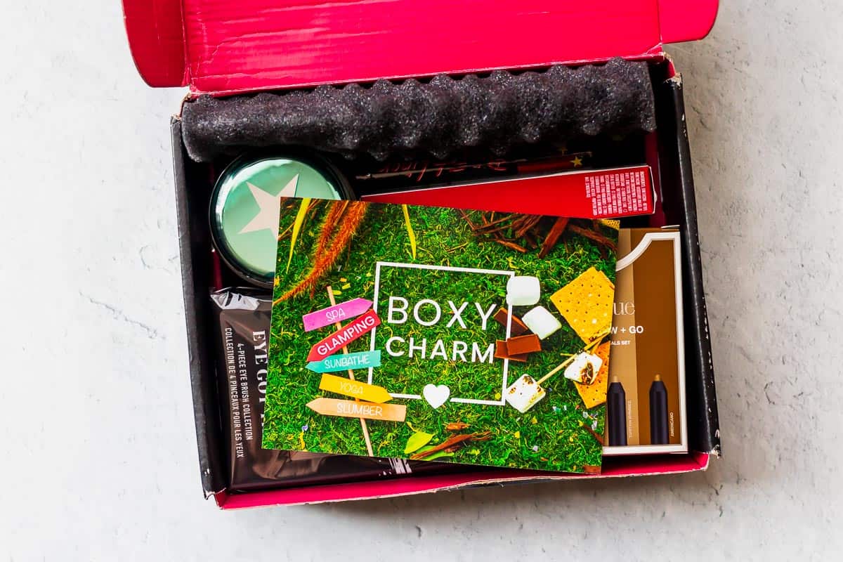 An opened august 2020 boxycharm box with the insert card on top of the products