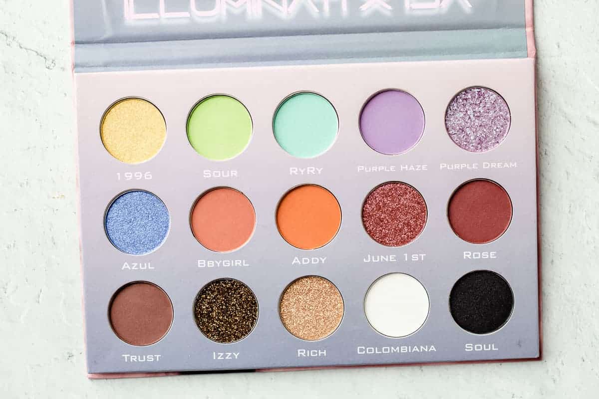 Illuminati x isa eyeshadow palette opened to show all of the shades on a white background