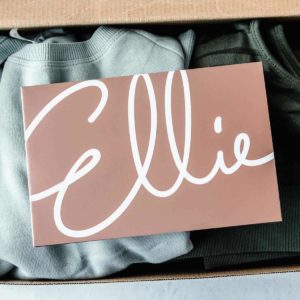 Ellie insert card on top of clothes in a box