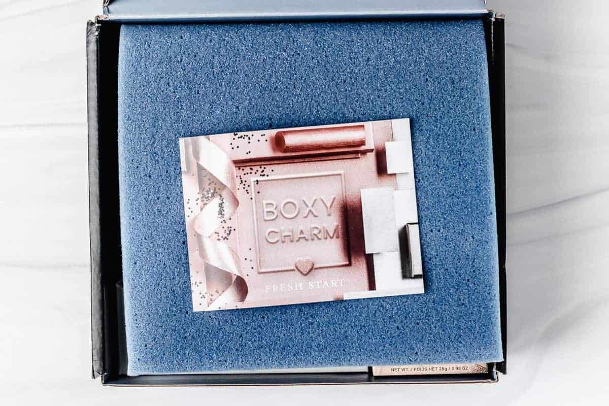 opened january 2021 boxycharm premium box with the insert card on top of the items