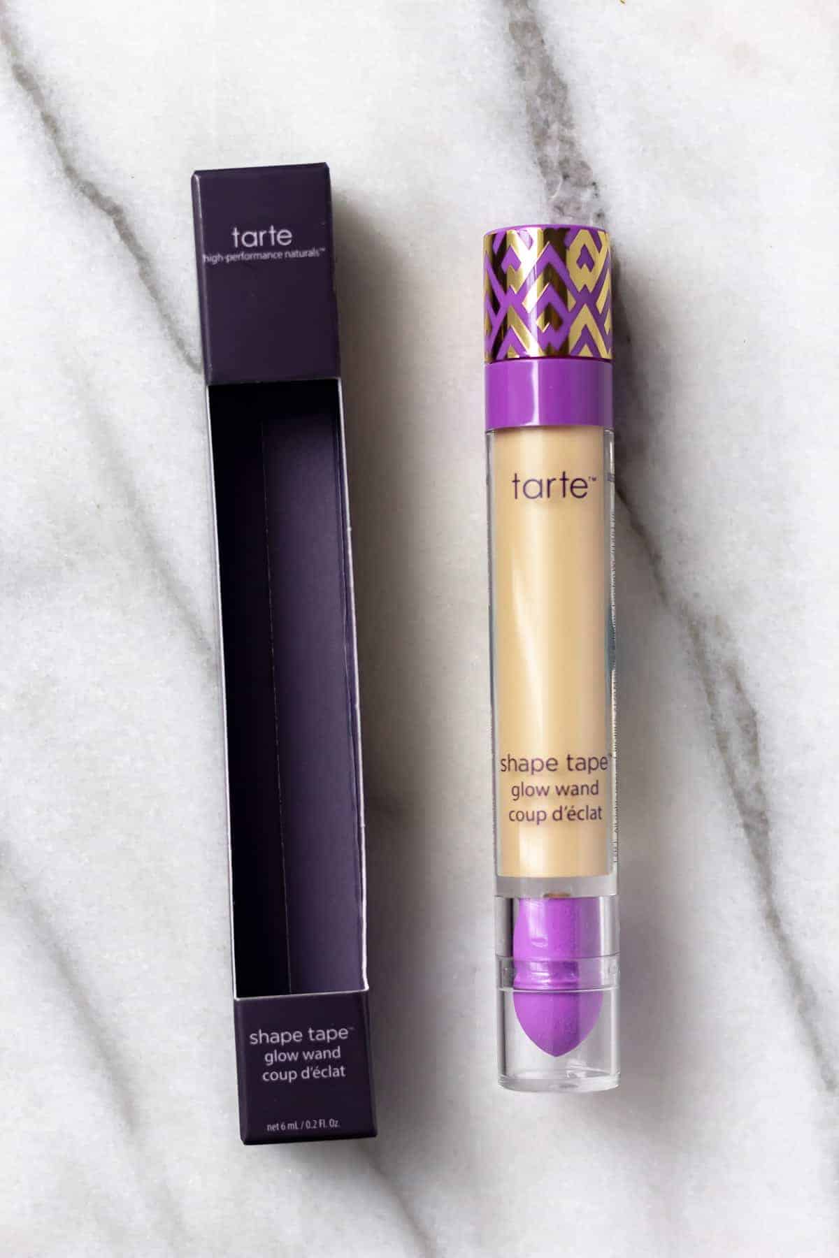 Tarte Shape Tape Glow Wand in Sunbeam and box on a marble background