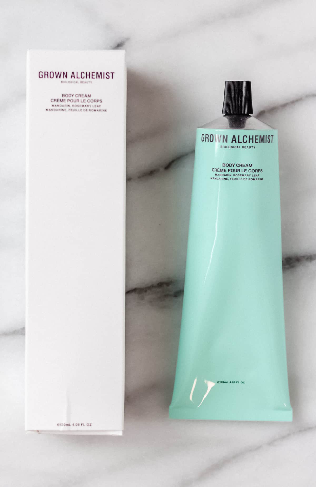 Grown Alchemist Body Cream box and tube on a marble backdrop