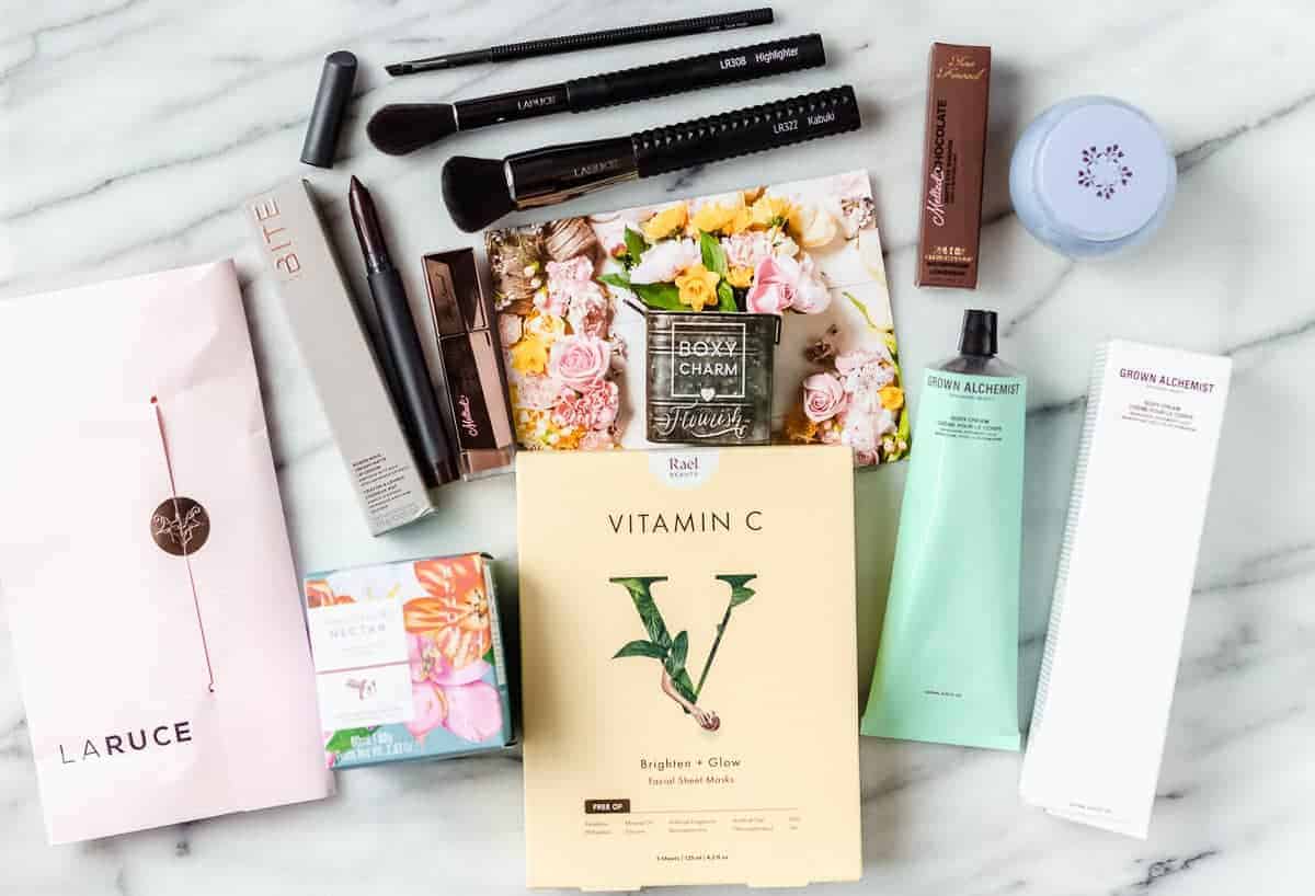 All of the beauty products that came in my May 2021 Boxycharm Premium box displayed on a marble backdrop