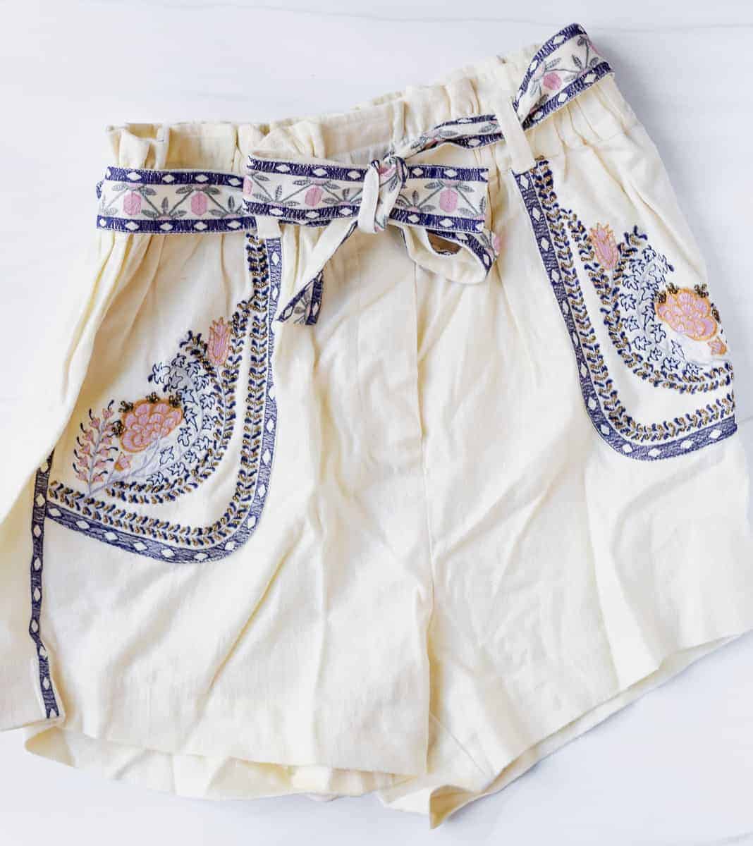 annaleigh embroidered shorts in cream with blue and pink details on a white background