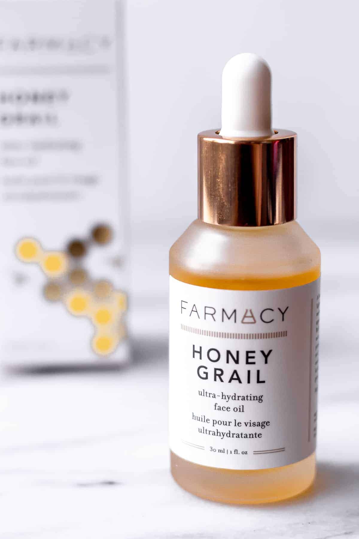 Farmacy Honey Grail Ultra-Hydrating Face Oil bottle and box on a marble background