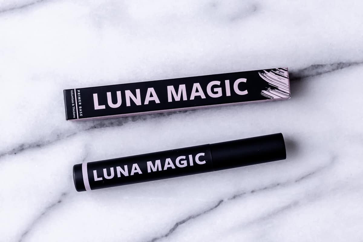 Luna Magic Beauty Va-Va Pink Lash Primer box and bottle on a marble background