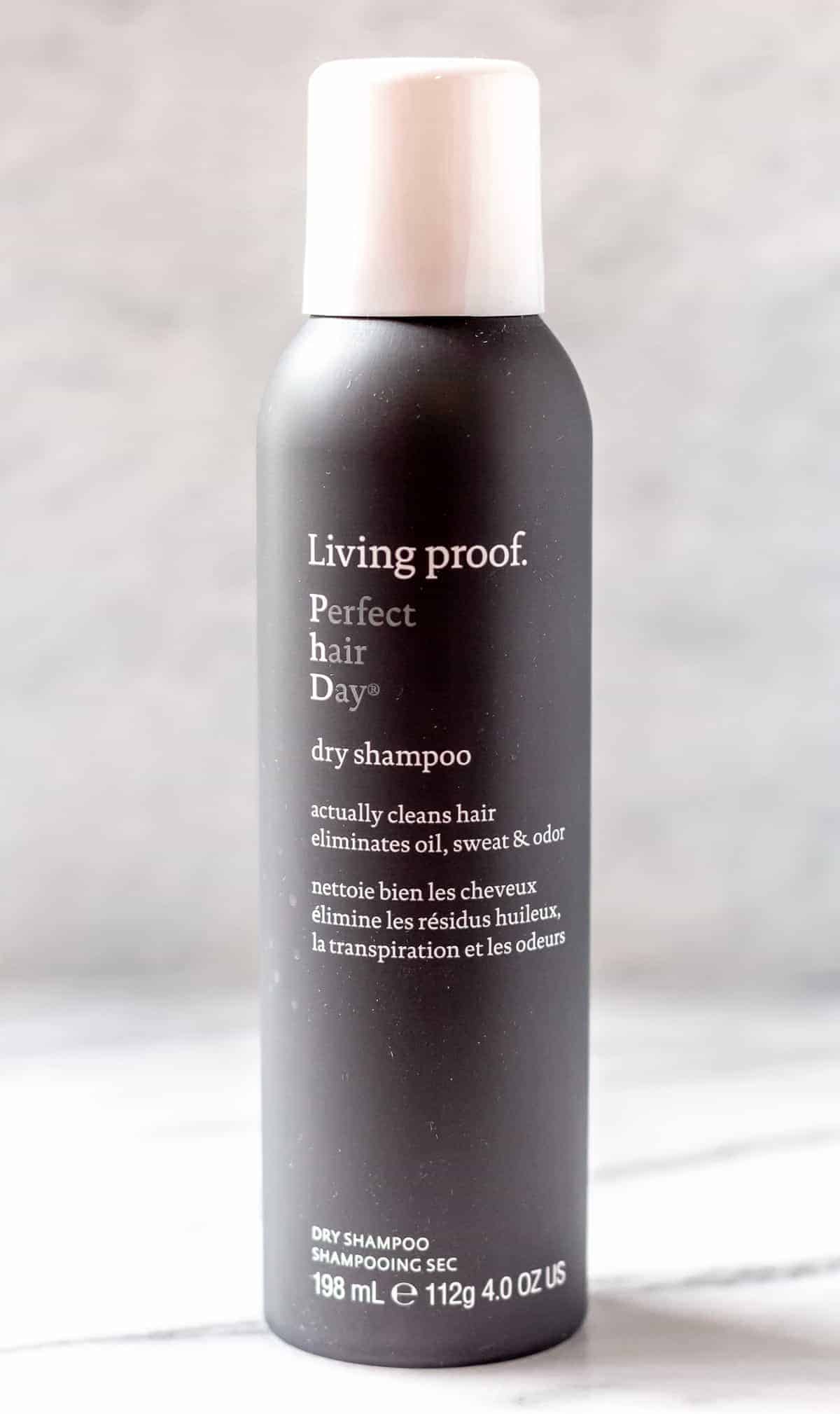Living Proof Perfect Hair Day Dry Shampoo over a gray background