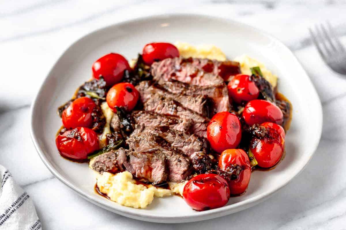 Seared Sirloin Steak Calabrese with Polenta & Balsamic Reduction from Gobble on a white plate