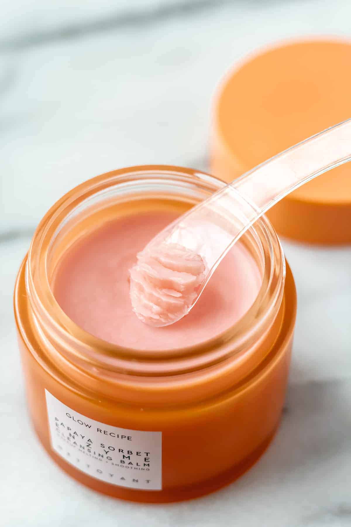 A scoop of Glow Recipe Papaya Enzyme Cleansing Balm on the spatula over the jar