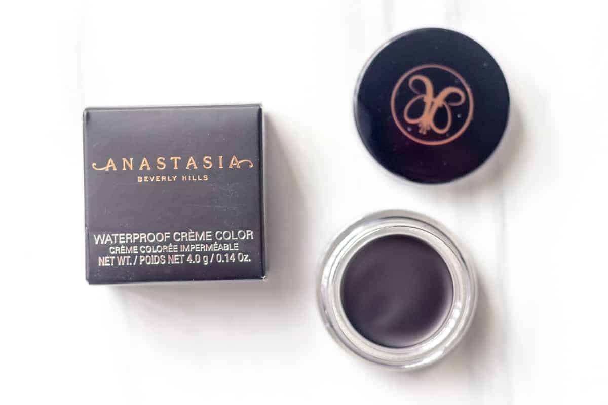 ANASTASIA BEVERLY HILLS Waterproof Creme Color in Black opened next to its box on a white background
