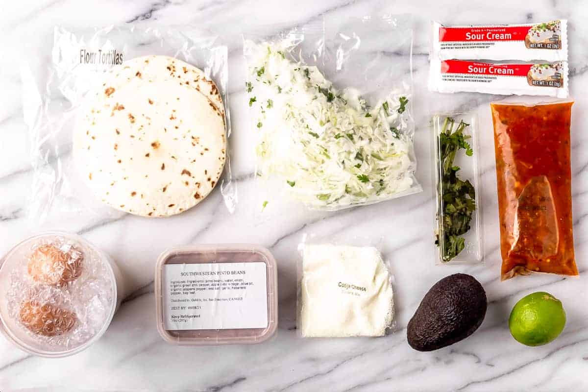 Ingredients to make Huevos Rancheros laid out on a marble backdrop