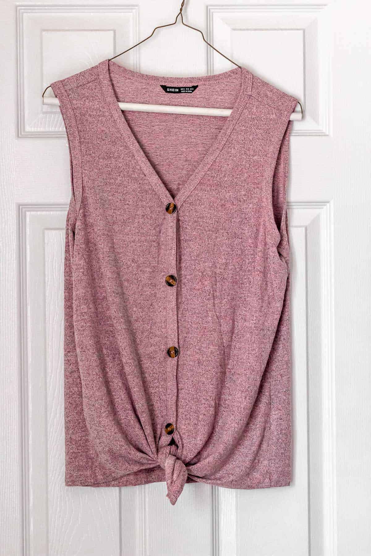 Button Front Knot Hem Tank Top in pink on a hanger