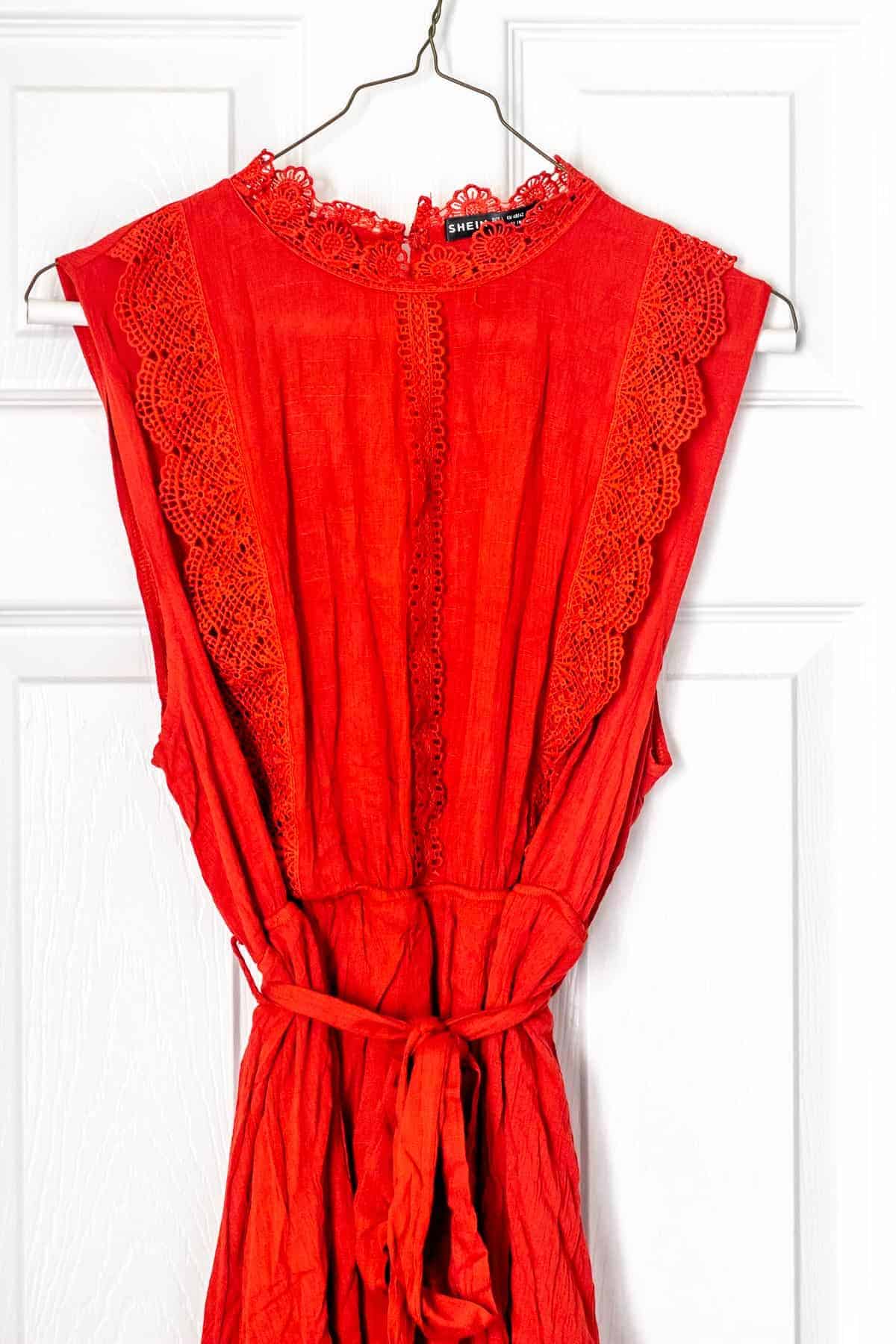 Close up of the top of a red dress on a hanger