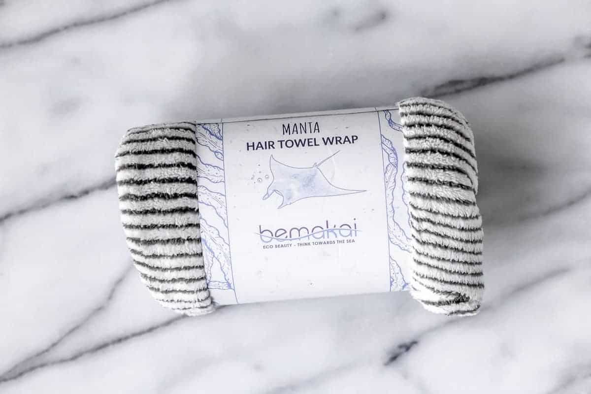 Bemakai Manta Hair Towel Wrap in its packaging on a marble background.