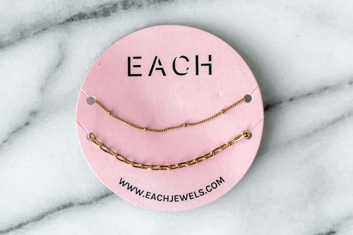 Each Jewels Layering Necklace Set on a marble background.