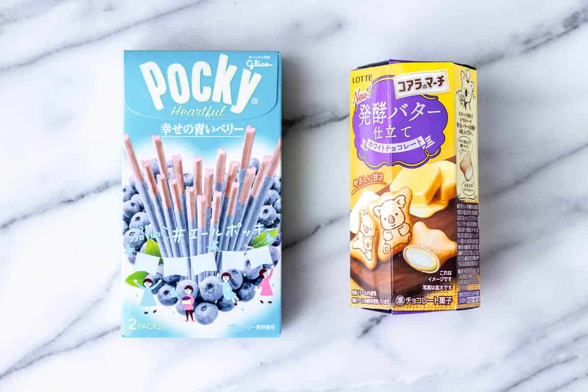 Japanese Pocky and koala cookies on a marble background.