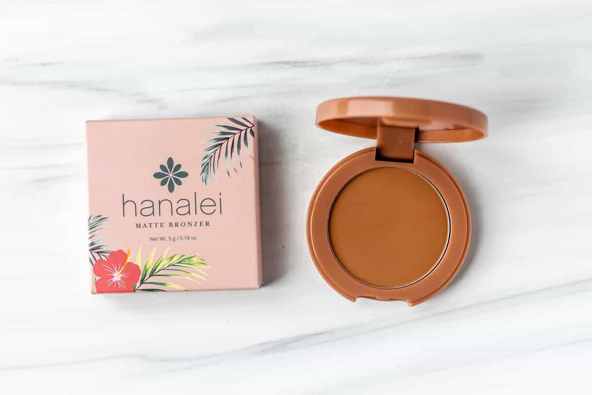 Hanalei Matte Bronzer box and compact opened to show color inside on a white background.