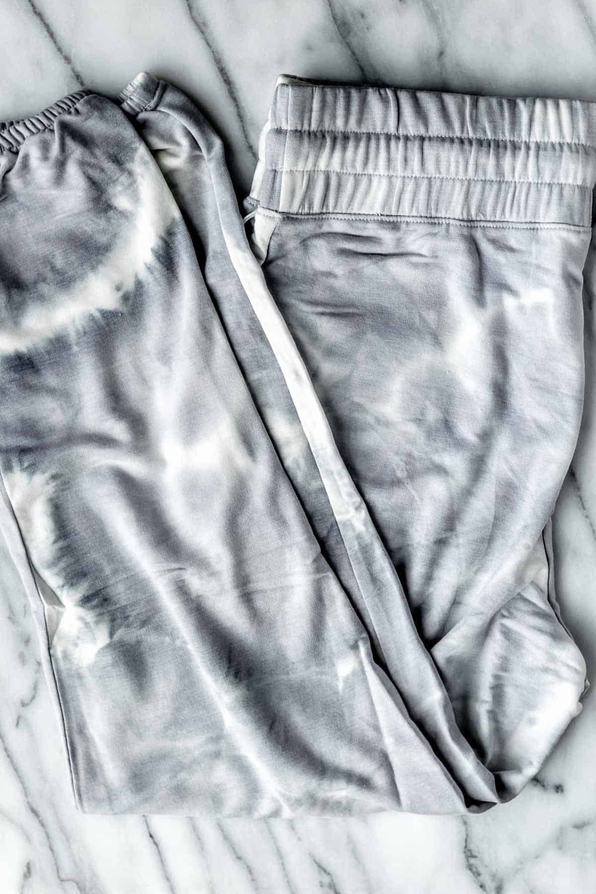 Balance Collection Tie-Dye Jogger in gray on a marble background.