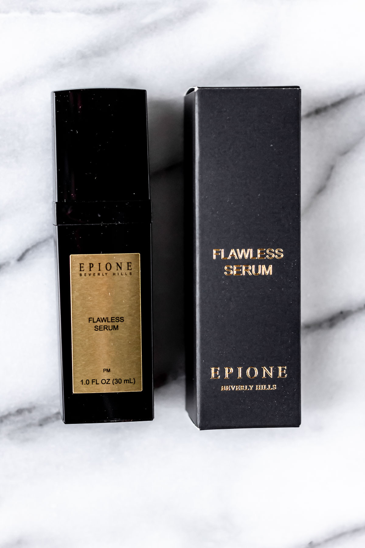 Epione Flawless Serum bottle and box on a marble background.