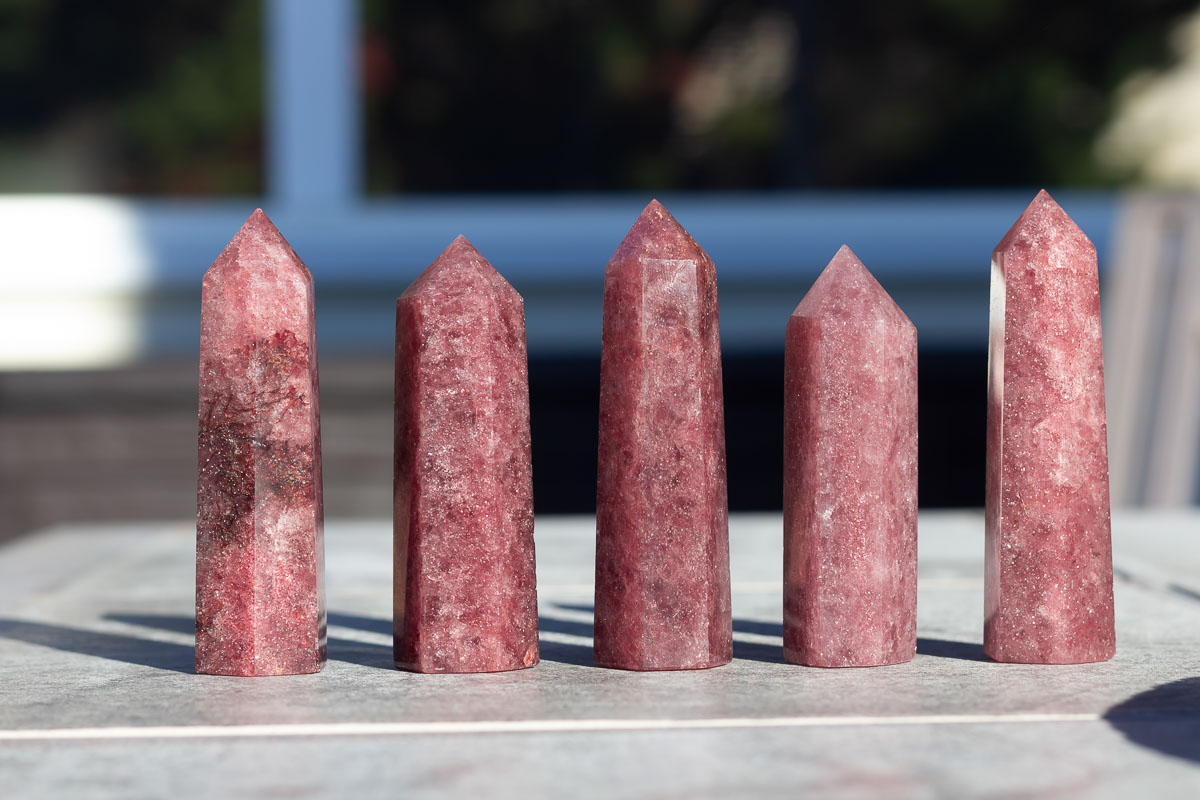 Five Red Aventurine Towers on a table.