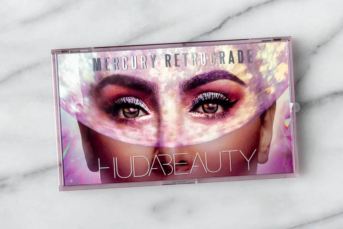 Huda Beauty Mercury Retrograde Eyeshadow Palette package on a marble background.