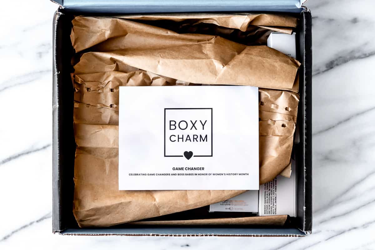 Opened March 2022 Boxycharm Premium box opened with the insert card on top of the packaging inside.