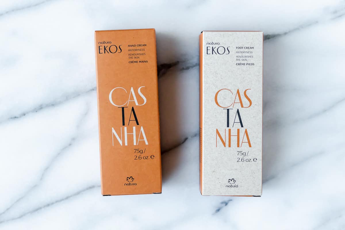 Natura's Castanha Hand & Foot Creams in boxes on a marble background.
