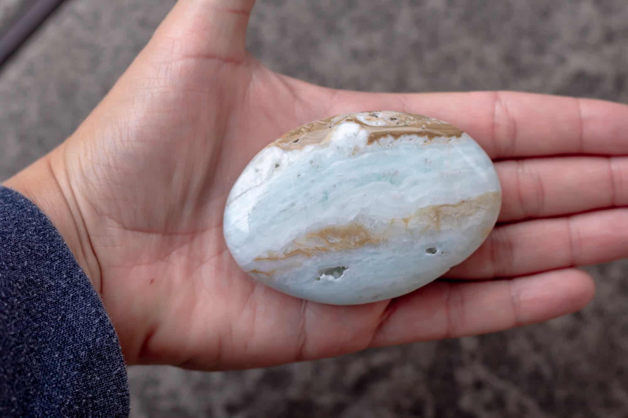 A Caribbean calcite palm stone in a hand.