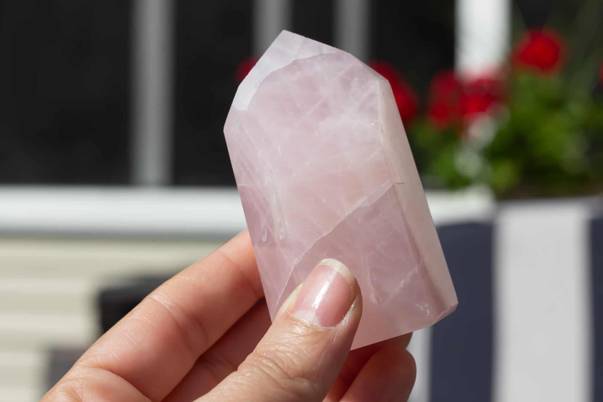 A rose quartz tower being held up.