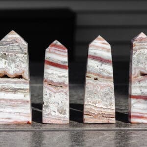 Four pink lace agate towers on a gray table.