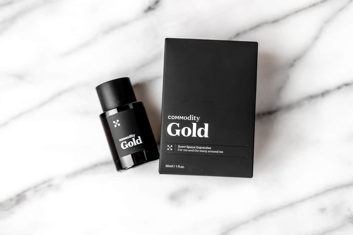 Commodity gold fragrance and the package on a marble background.