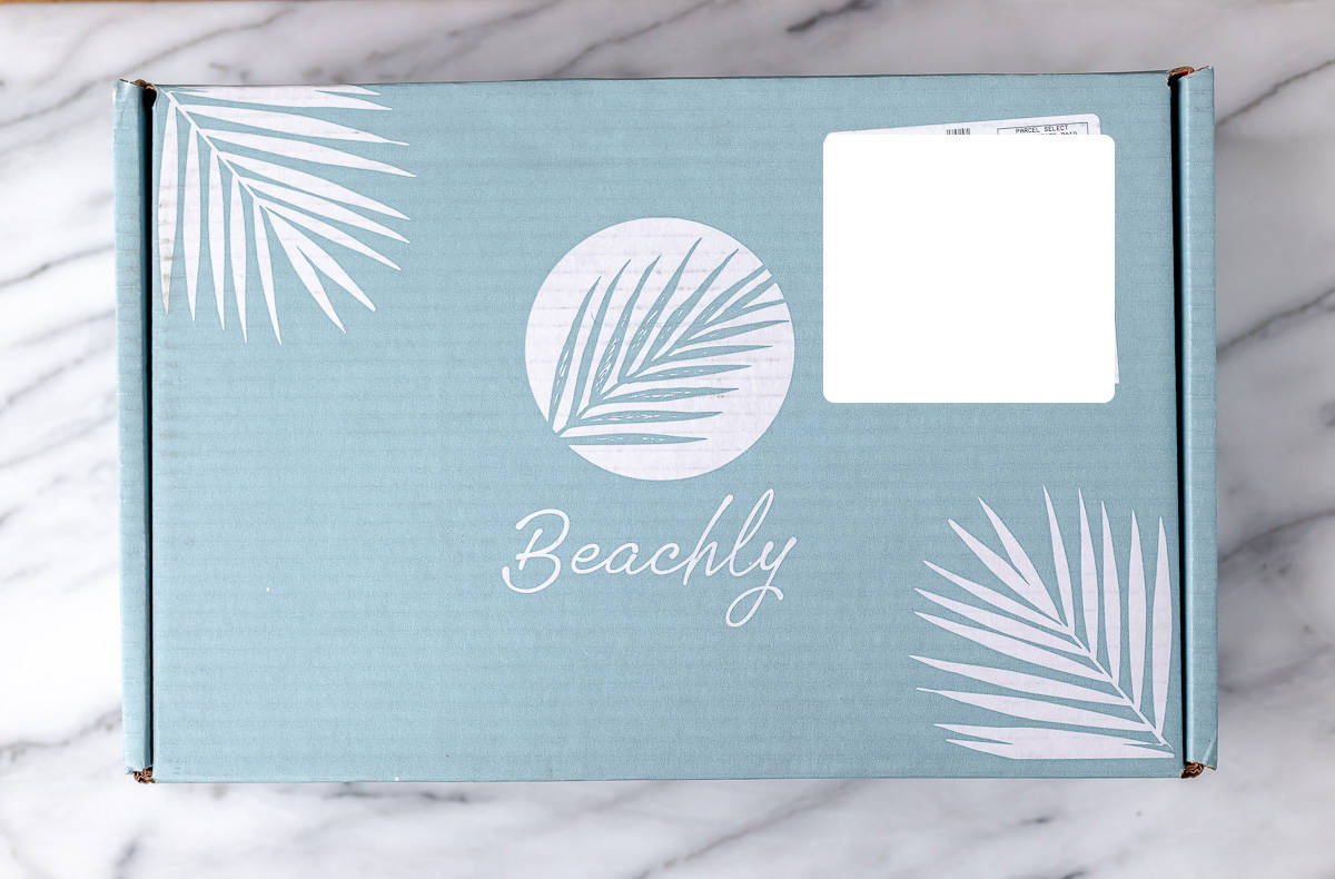A beachly subscription box on a marble background.