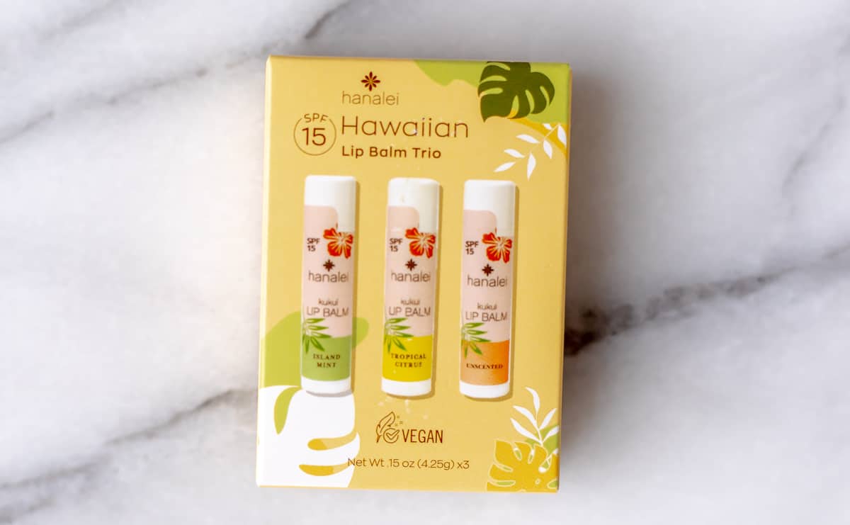 Kukui Lip Balm Trio by Hanalei Beauty in box over a marble baackground.