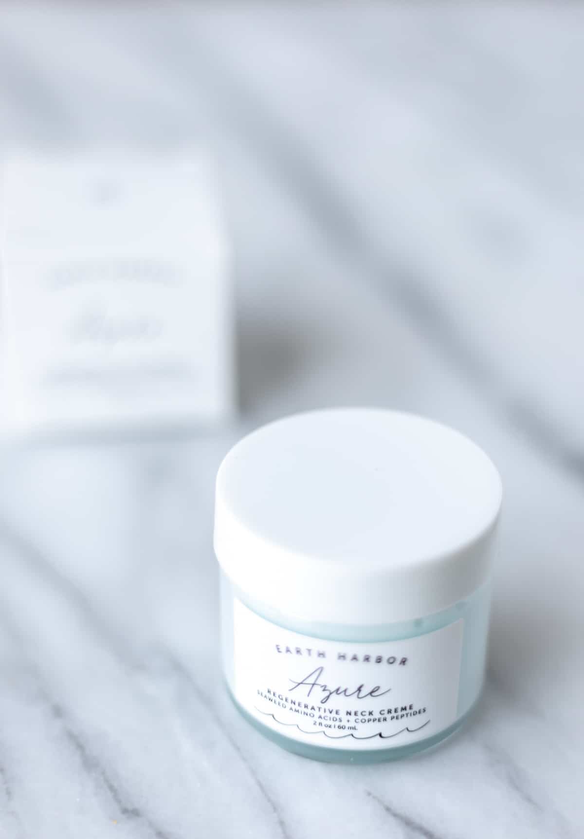 A jar of Earth Harbor Azure Regenerative Neck Cream with the box behind it.