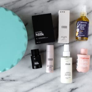 The cake stand and beauty products that came in my Winter 2023 Fabfitfun box on a marble background.