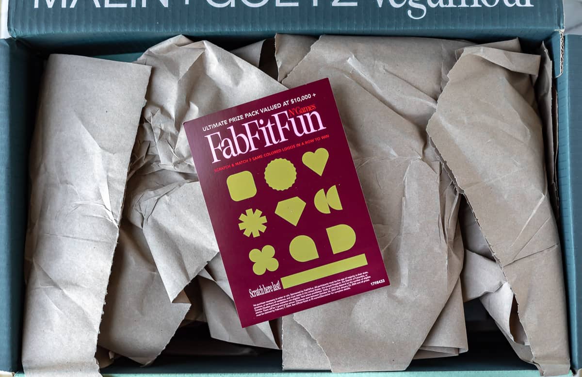 Opened Fabfitfun box with packing paper and a scratch off card on top.