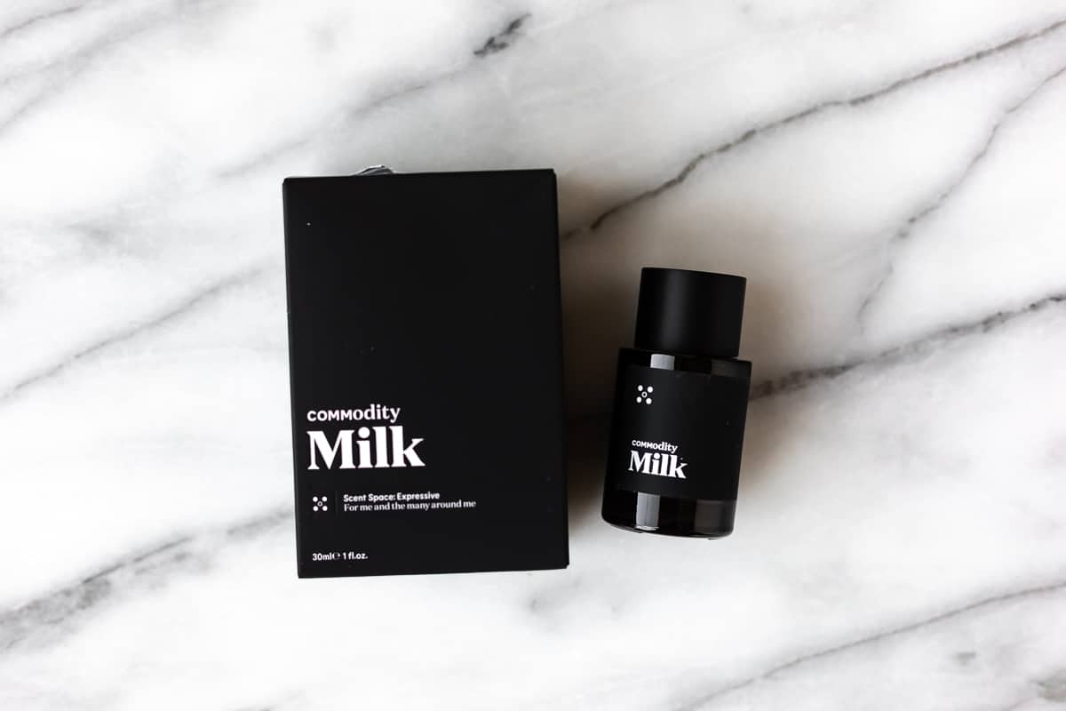 Commodity Milk fragrance box and bottle on a marble background.