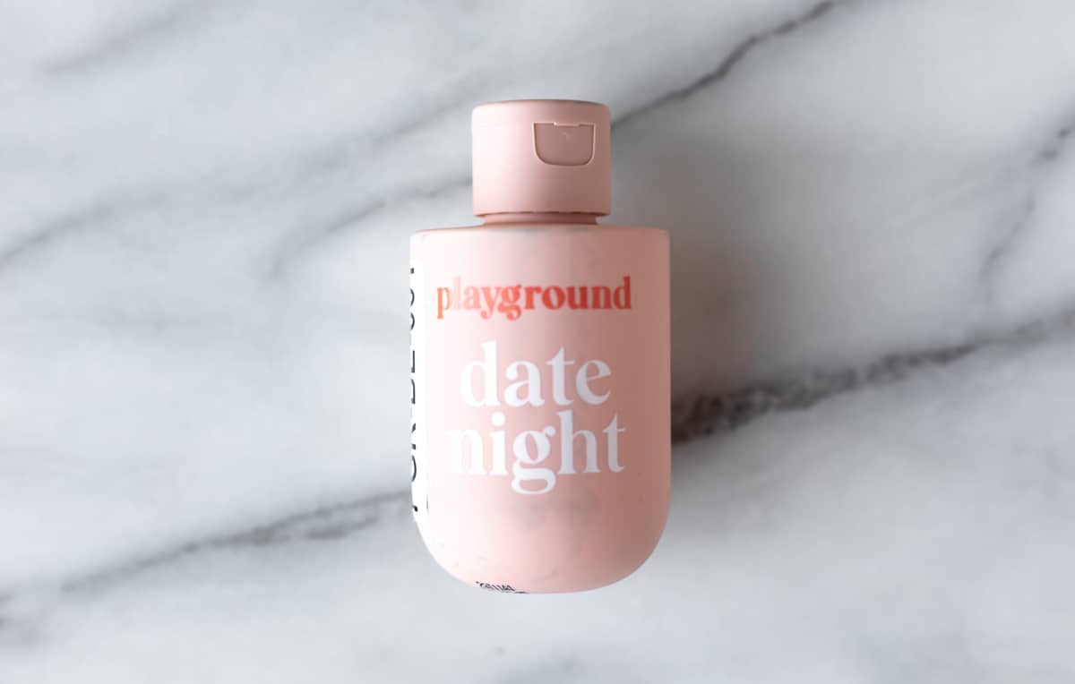 Playground Date Night bottle on a marble background.