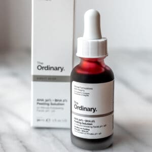 The Ordinary Peeling Solution bottle and box on a marble background.