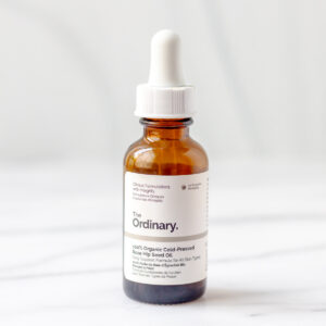 A bottle of The Ordinary Rose Hip Seed Oil on a marble background.